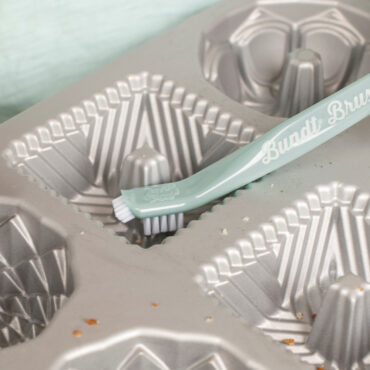 Closeup of Bundt Cleaning Tool showing brush end of tool being used in cavity of a pan