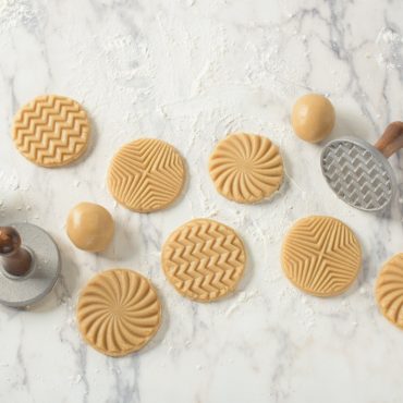 Stamped cookie dough with geo cookie stamps on surface