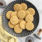 Baked honeybee stamped sugar cookies on metal plate, cookie stamps around plate