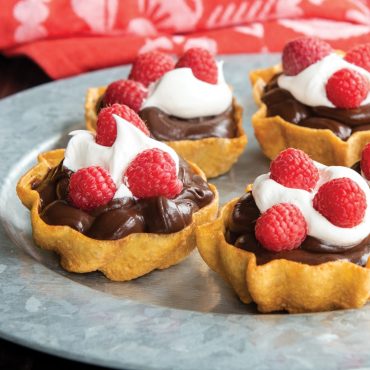 Cooked timbales filled with chocolate pudding, whipped cream, and raspberries