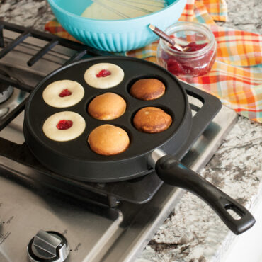 Nordic Ware cast iron Danish ebelskiver pan with seven round wells, black finish, shown from above
