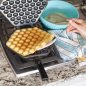 Open waffler with cooked puff waffle on stovetop