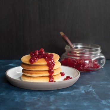 Lingonberry jam on top of stacked pancakes.