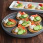 Pancakes on platter with savory topping of smoked salmon, cucumber, dill and cream cheese