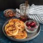Plate with pancakes, syrup, nuts, fresh cherries
