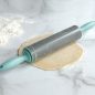 Rolling pin on top of rolled out pie crust dough, flour on surface