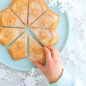 Baked shortbread, 8 diamond shape pieces with hand grabbing a piece