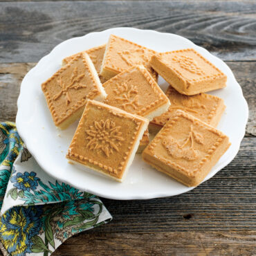 Nine golden shortbread squares baked in Nordic Ware English shortbread pan, showing detailed embossed patterns