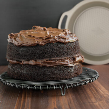 Nordic Ware aluminum 9-inch round cake pan with textured non-stick surface, natural silver finish with chocloate layer cake