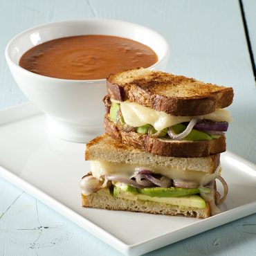 Grilled sandwich on plate, bowl of tomato soup