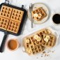 Plated banana oat waffles with peanut butter syrup and coffee scene