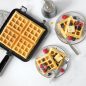 Classic Waffle plated with syrup, butter and berries. Cooked waffle on waffler
