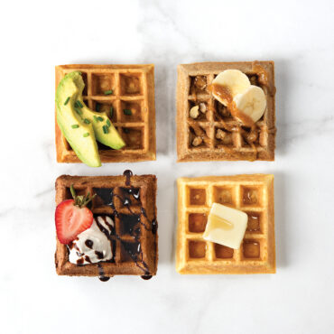4 cooked waffle squares in a quadrant with different toppings