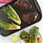 Grilled romaine lettuce and steak on flag griddle, grilled salad on side