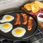 Fried eggs and bacon on flat griddle side on stovetop