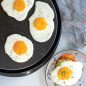 Fried eggs on flat griddle side, egg on toast, on plate