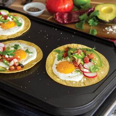 Breakfast tacos with fried eggs, avocado and salsa on Nordic Ware aluminum reversible griddle flat side