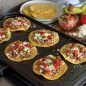 Meat, cheese, vegetable tostadas on griddle on stovetop