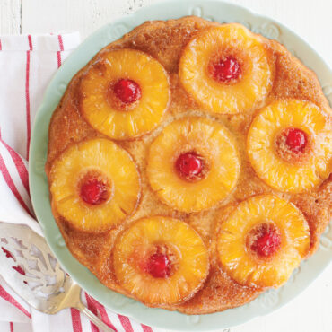 Nordic Ware aluminum pineapple upside-down cake pan with golden baked cake showing caramelized pineapple rings