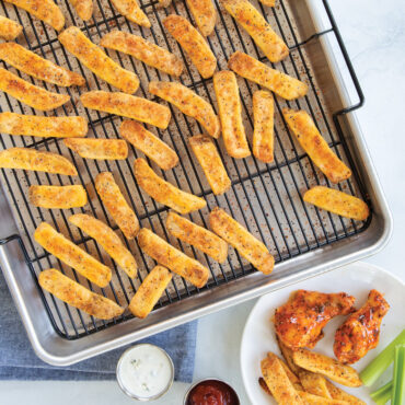 Golden brown french fries on Nordic Ware Extra Large Oven Crisp aluminum baking tray with perforated surface