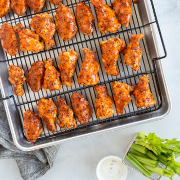 Crispy golden chicken wings arranged on Nordic Ware Extra Large Oven Crisp aluminum baking tray with perforated surface