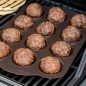Grilled meatballs in pan on grill