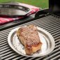 Grilled steak on stainless steel tray, on grill