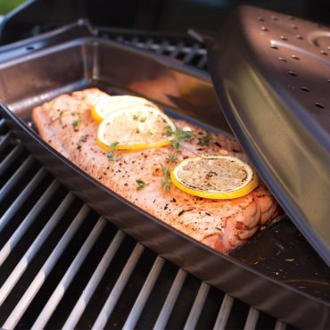 Grilled salmon in open cooker on grill