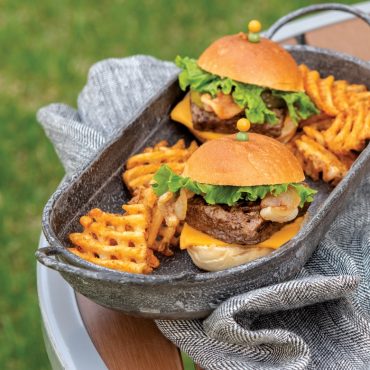 Two grilled square sliders on tray, towel