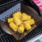 Grilled corn in grill basket on grill