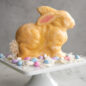 Baked bunny cake standing on cake stand, glazed, Easter scene