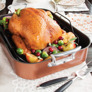 Golden roasted turkey with vegetables in Nordic Ware copper roaster with removable rack, beautifully browned