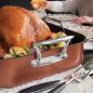 Close up cooked turkey in roaster, carving tools