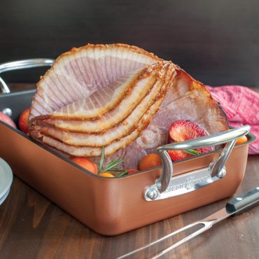 Cooked ham in roaster with stone fruit