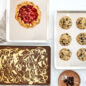 3 half sheets with baked goods such as a gallette, cookies and brownie bars