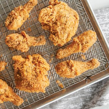 Baked fried chicken on grid in Prism pan