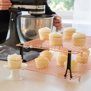Nordic Ware copper stackable cooling grids with vanilla cupcakes, wire mesh design with black support legs