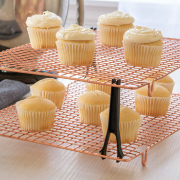 Nordic Ware copper stackable cooling grids with vanilla cupcakes, wire mesh design with black support legs