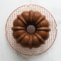 Bundt Cake on copper round cooling grid, overhead on marble