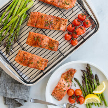 Golden baked salmon fillet with roasted asparagus and cherry tomatoes on Nordic Ware aluminum sheet pan