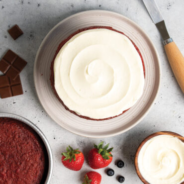 frosted layer cake plated next to nordic ware 6 in round cake pan filled with baked cake