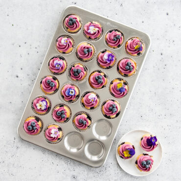 Naturals® 24 Cavity Petite Muffin Pan with baked and iced cupcakes
