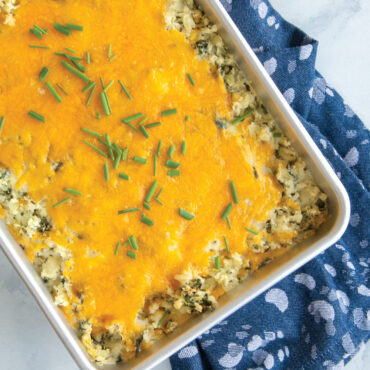 Cheesy potato casserole with melted cheddar and chives in Nordic Ware Prism aluminum 9x13 baking pan