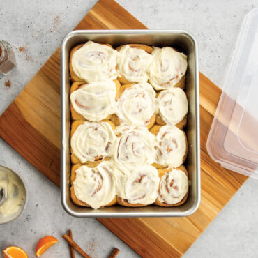 nordic ware 9x13 rectangular cake pan with lid filled with cinnamon rolls