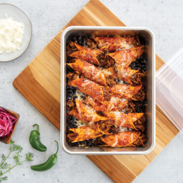nordic ware 9x13 rectangular cake pan with lid filled with enchiladas