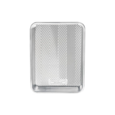 Nordic Ware Prism aluminum 9x13 rectangular baking pan with geometric chevron pattern, natural finish
