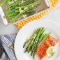 Roasted asparagus with cheese in pan, plated baked salmon, asparagus, lemon slice
