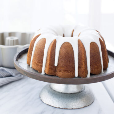 Baked Bundt on cake plate with product in background
