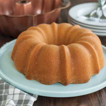 Plain yellow bundt cake on sea glass platter  baked in ProForm Anniversary Bundt Pan with Handles