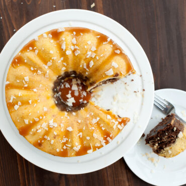 Sliced chocoflan dessert baked in Nordic Ware bundt springform pan with caramel drizzle, overhead view